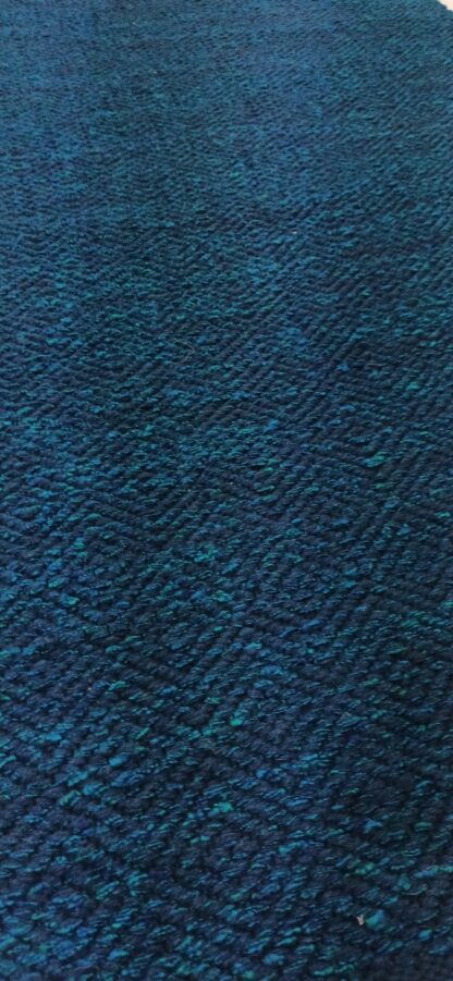 Villane kangastelgedel kootud ristoimelise koega sinine vaip