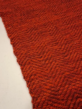 Punane kangastelgedel kootud villane vaip